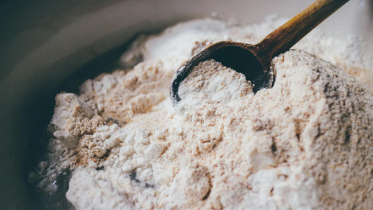 Wheat flour with a wooden spoon — the wheat breading is the main source of gluten at Dave's Hot Chicken