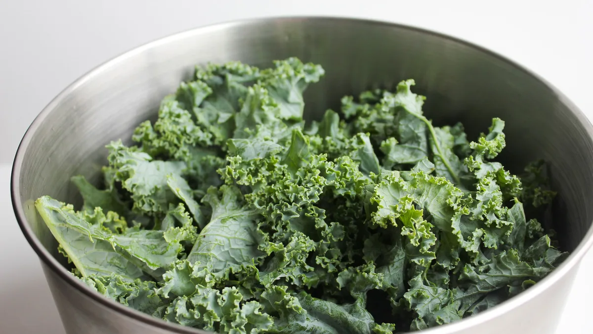 Fresh kale in a bowl — kale slaw is one of the few lower-risk sides at Dave's Hot Chicken