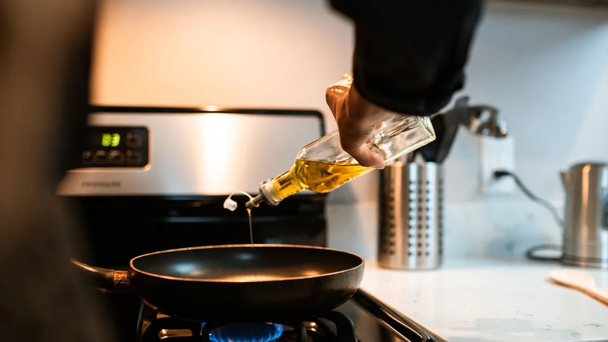 Neutral cooking oil being poured into a pan — Dave's Hot Chicken uses a soybean-based vegetable oil