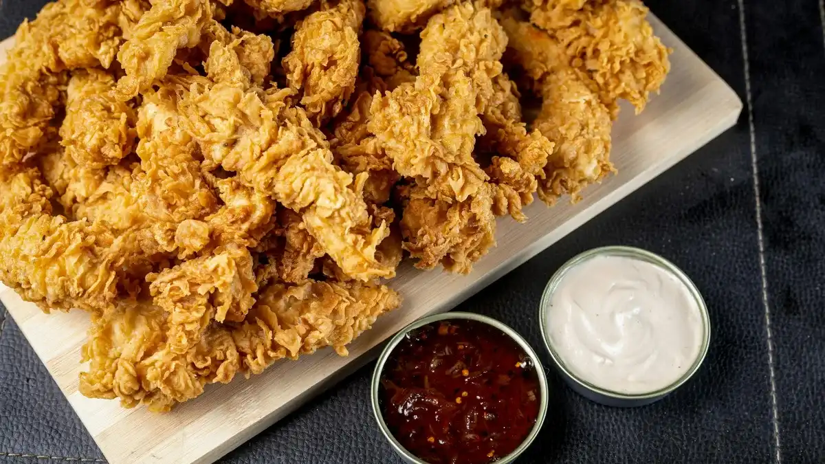 Crispy fried chicken tenders with two dipping sauces — the Dave's Hot Chicken dipper lineup