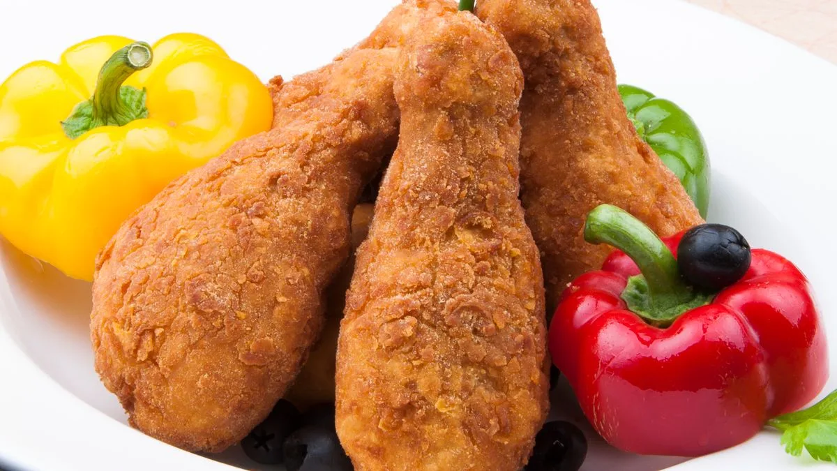 A plate of bone-in fried chicken drumsticks — KFC's classic format versus Dave's tenders