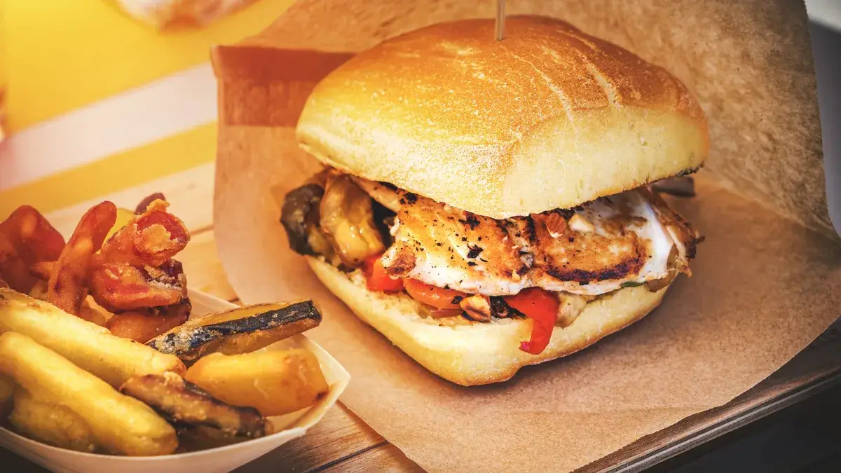 A crispy fried chicken slider with a side of fries — the must-try item at Dave's Hot Chicken
